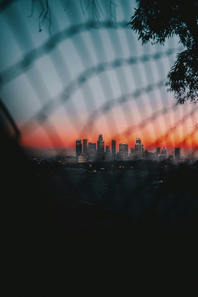 A beautiful sunset image of the Los Angeles city skyline with a blue sky fading into a deep red horizon.